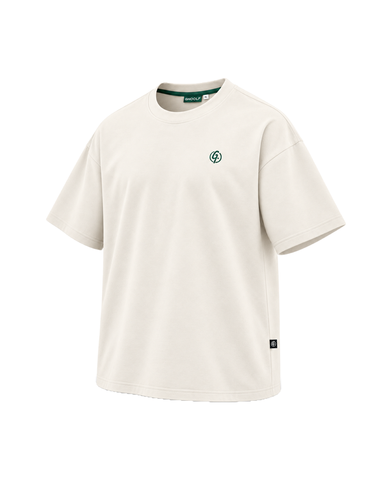 Ivory Ghoolf mock neck tee, three-quarter view, with forest green signet on the chest and woven tab at the side seam