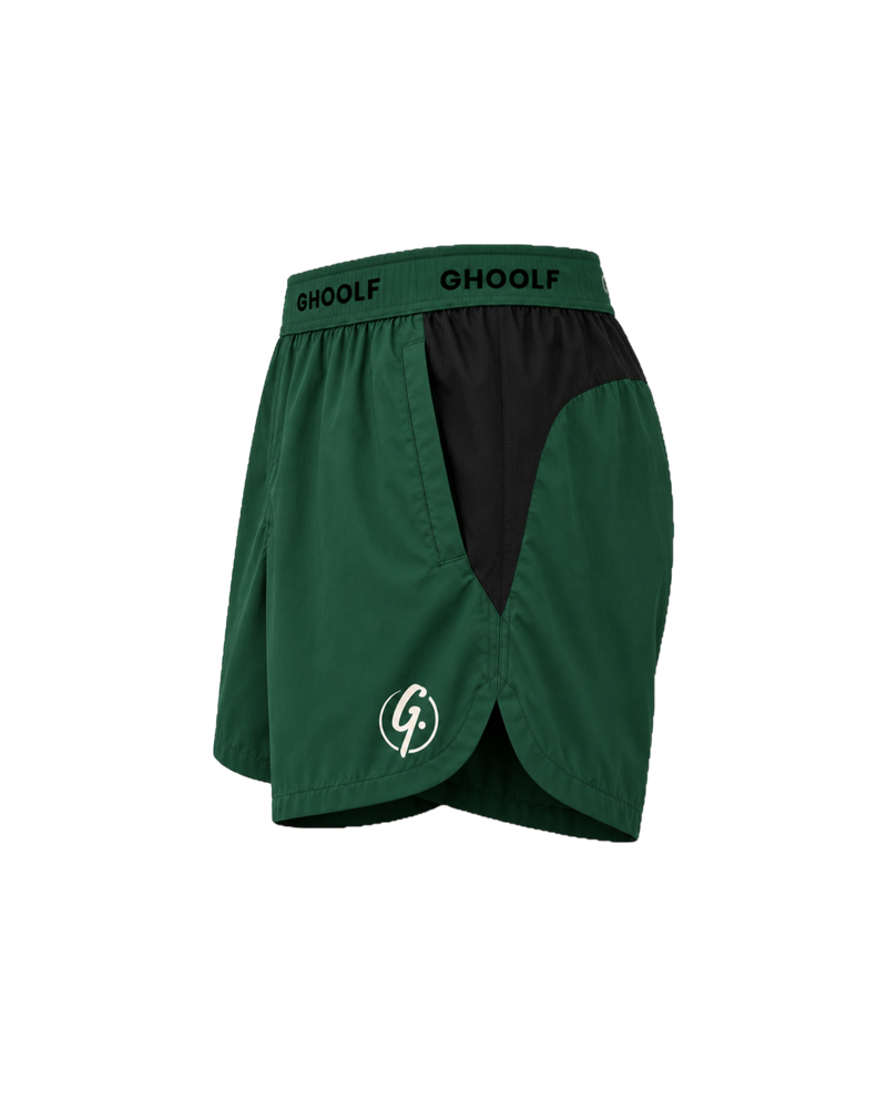 Forest green Ghoolf sport shorts with black side panels, side view, with signet at the hem