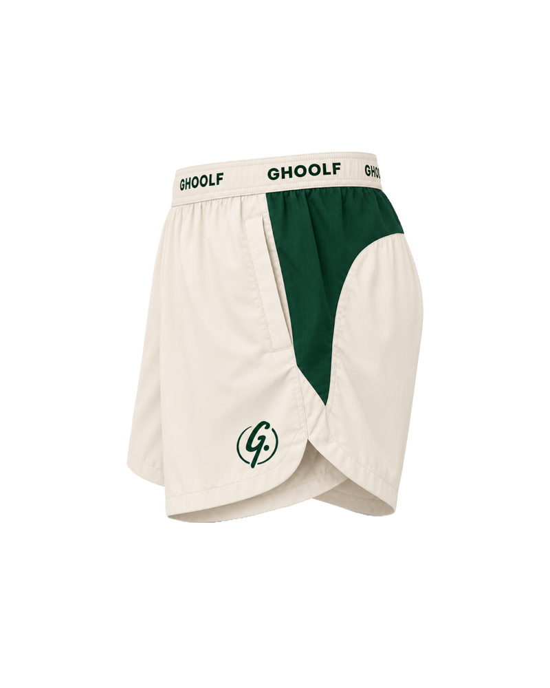 Ivory Ghoolf sport shorts with forest green side panels, side view, with signet at the hem