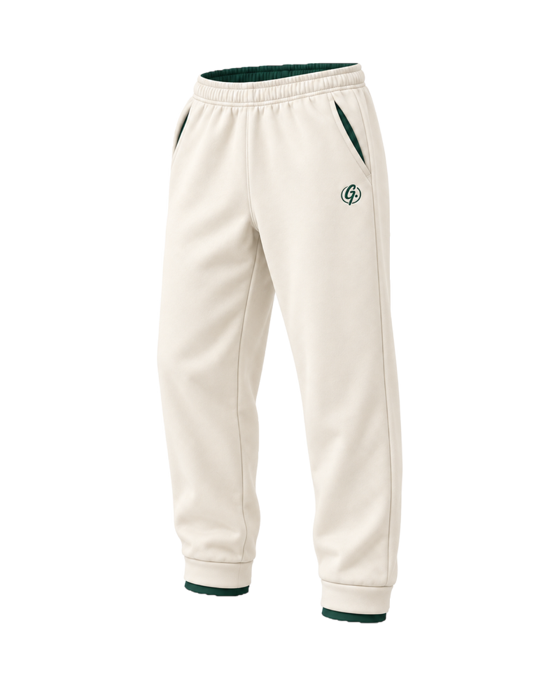 Ivory Ghoolf sweatpants, three-quarter view, with forest green signet at the hip and cuffed hem