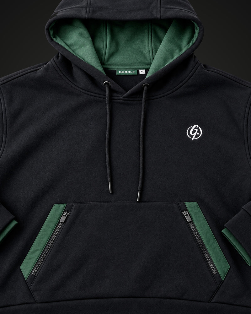 Front of the black hoodie showing two zip pocket openings framed in forest green